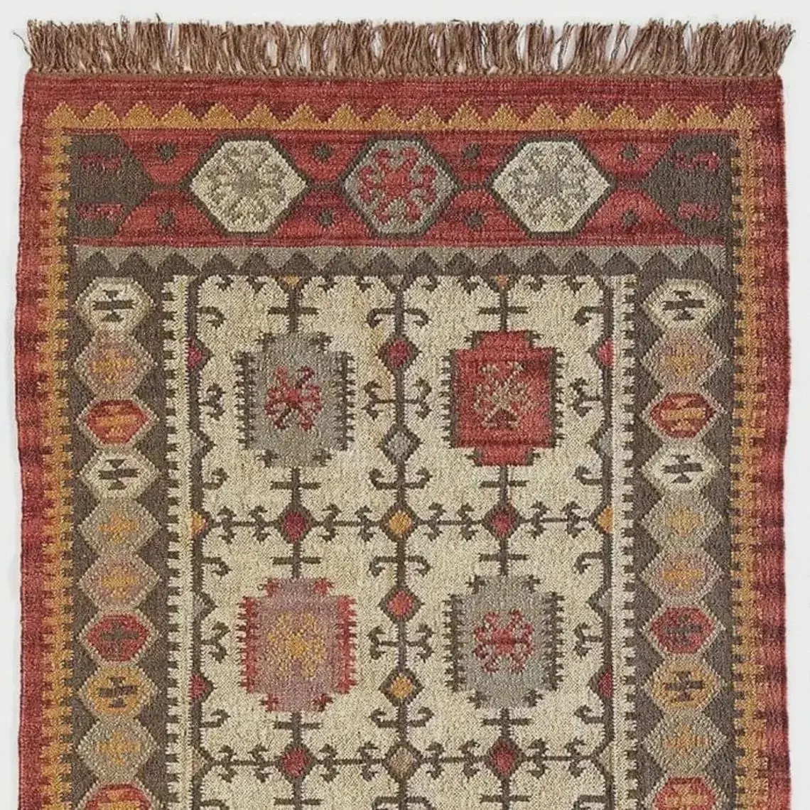 Rust and ivory flat-woven rug with hexagonal medallions and an ochre sawtooth border